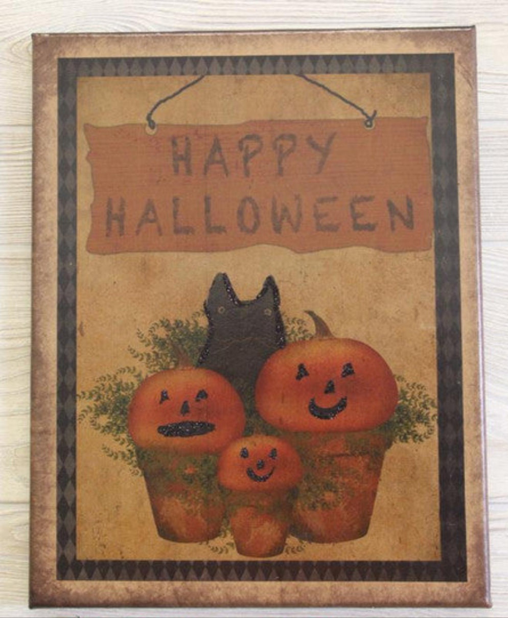 Canvas print the words "Happy Halloween" over a group of three potted pumpkins and a black cat