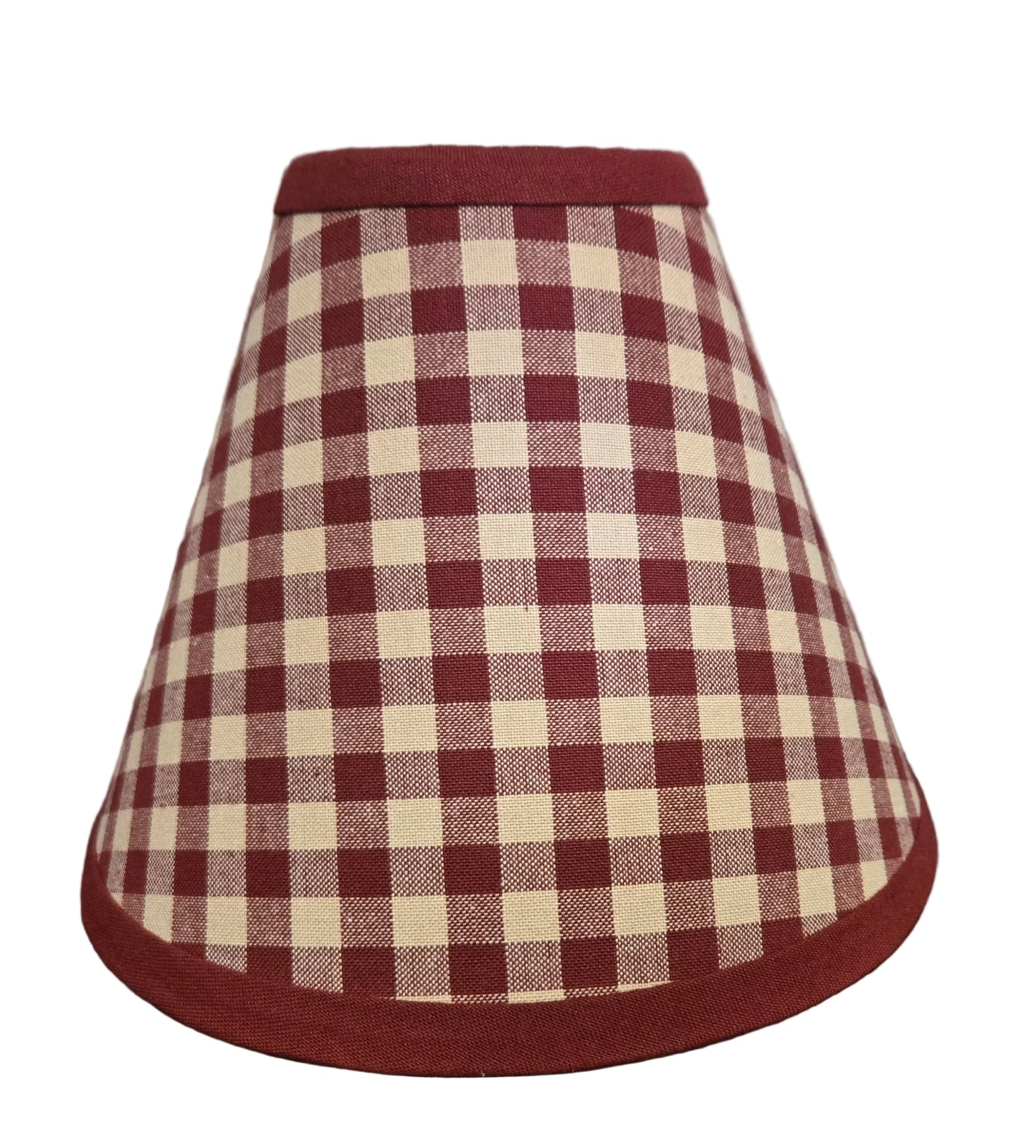 Red and white checkered lampshade on a wooden surface with a rustic background