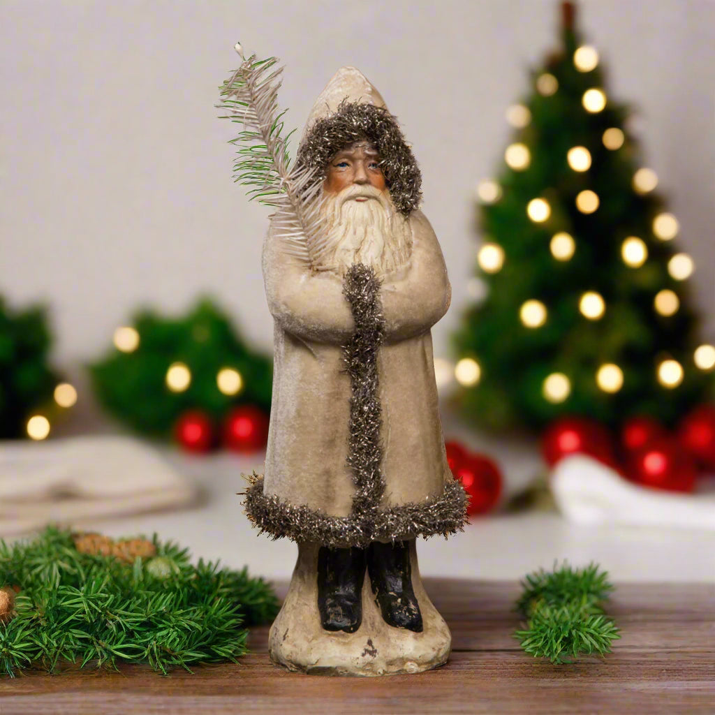 12 inch ivory color belsnickel holding branch on wood surface.