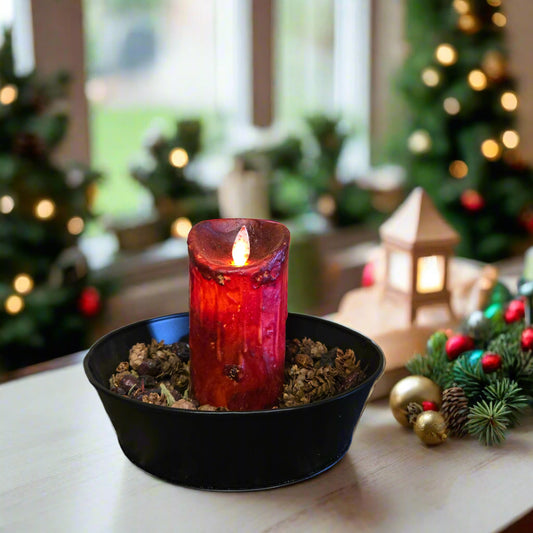 A burgundy colored LED candle with a moving flame effect, placed in a black holder on a patterned surface.