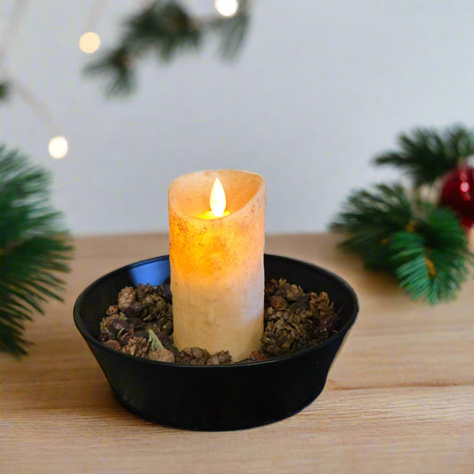 An LED candle with a moving flame effect, placed in a black holder on a textured mat, depicting a burnt ivory color.