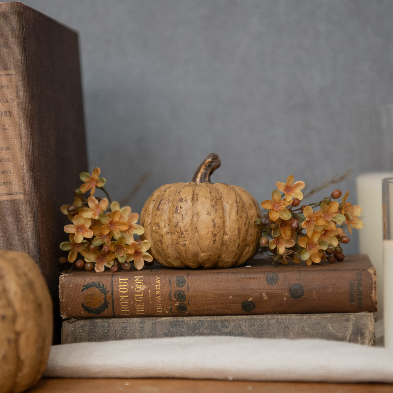 Beige short primitive pumpkin on an old book with greenery
