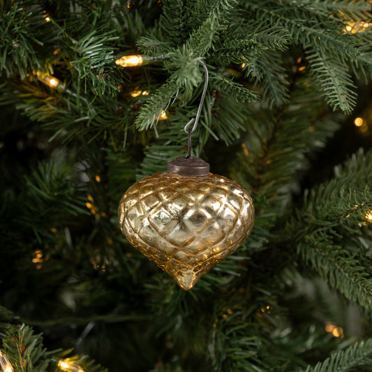 Decorative gold ornament on a Christmas tree with lights