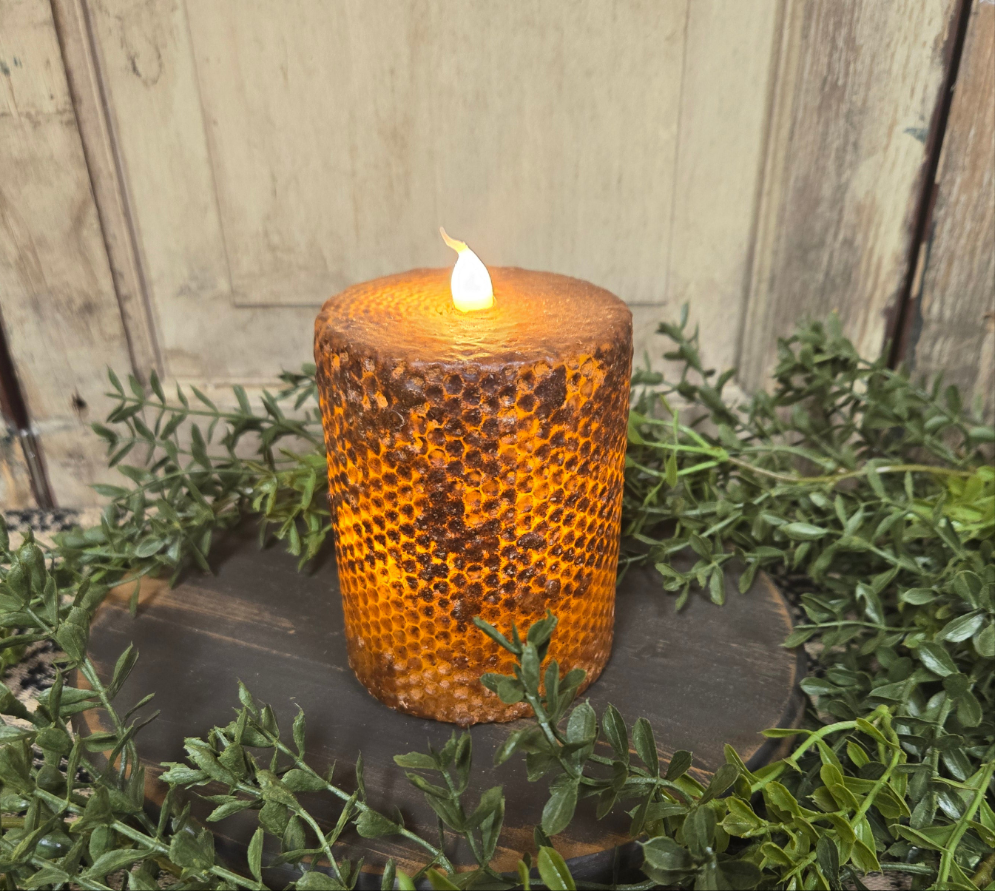 Brown honeycomb pillar candle that runs on batteries and has a timer feature.