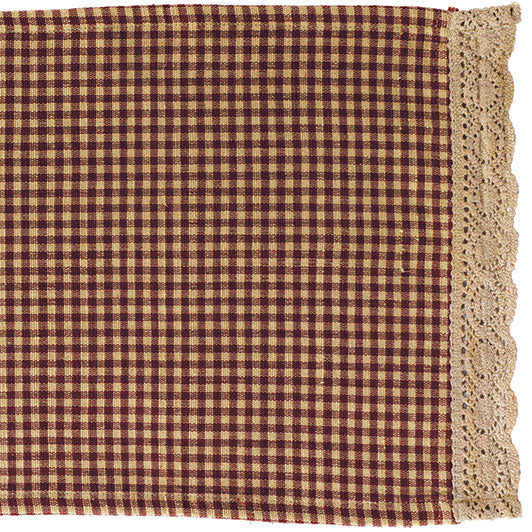 A rectangular burgundy and beige checkered table runner with a lace border.
