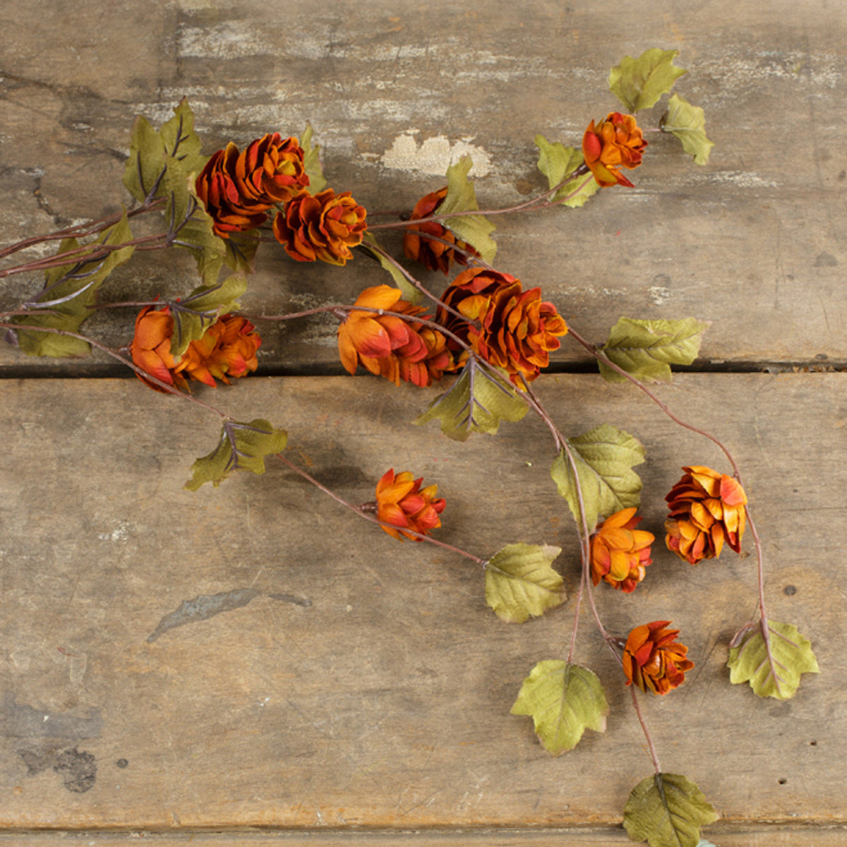 A bunch of artificial Sienna Hops stems with realistic floral details, placed on a wooden surface.