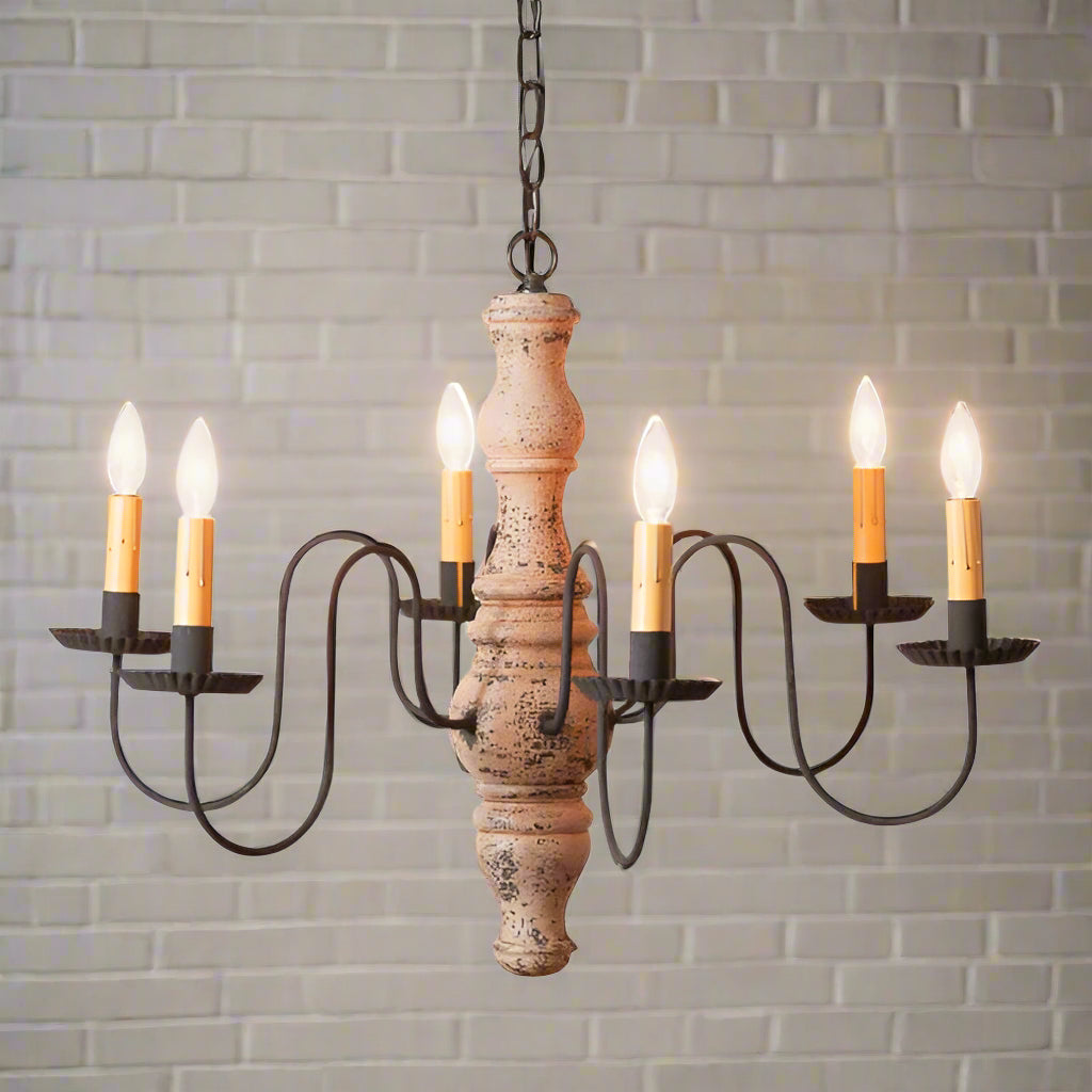 A Gettysburg wooden chandelier with a Hartford buttermilk finish, featuring a textured painted design, black distressed arms, and hanging from a chain.