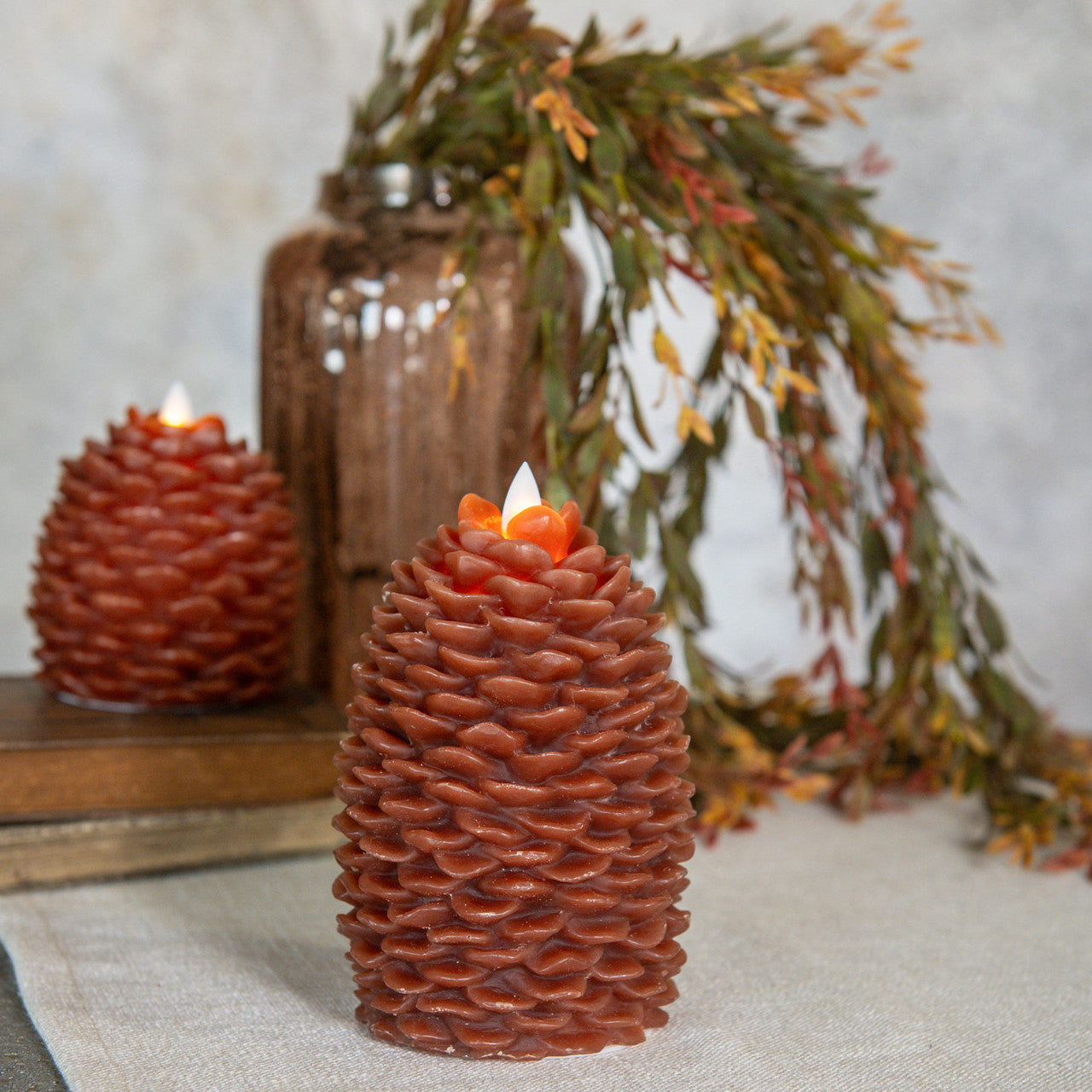 Decorative pine cone-shaped candles with a blurred background