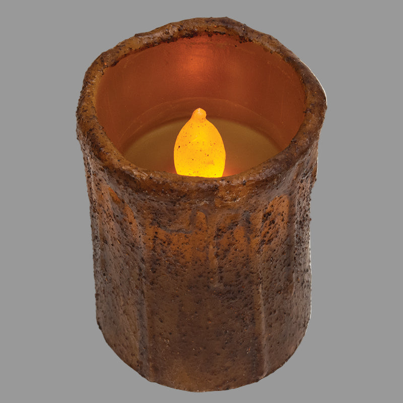 Decorative candle with a textured brown holder on a gray background