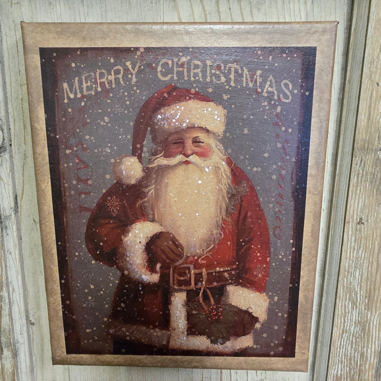 A canvas print featuring a colorful illustration of Santa Claus with 'Merry Christmas' text and decorative elements.