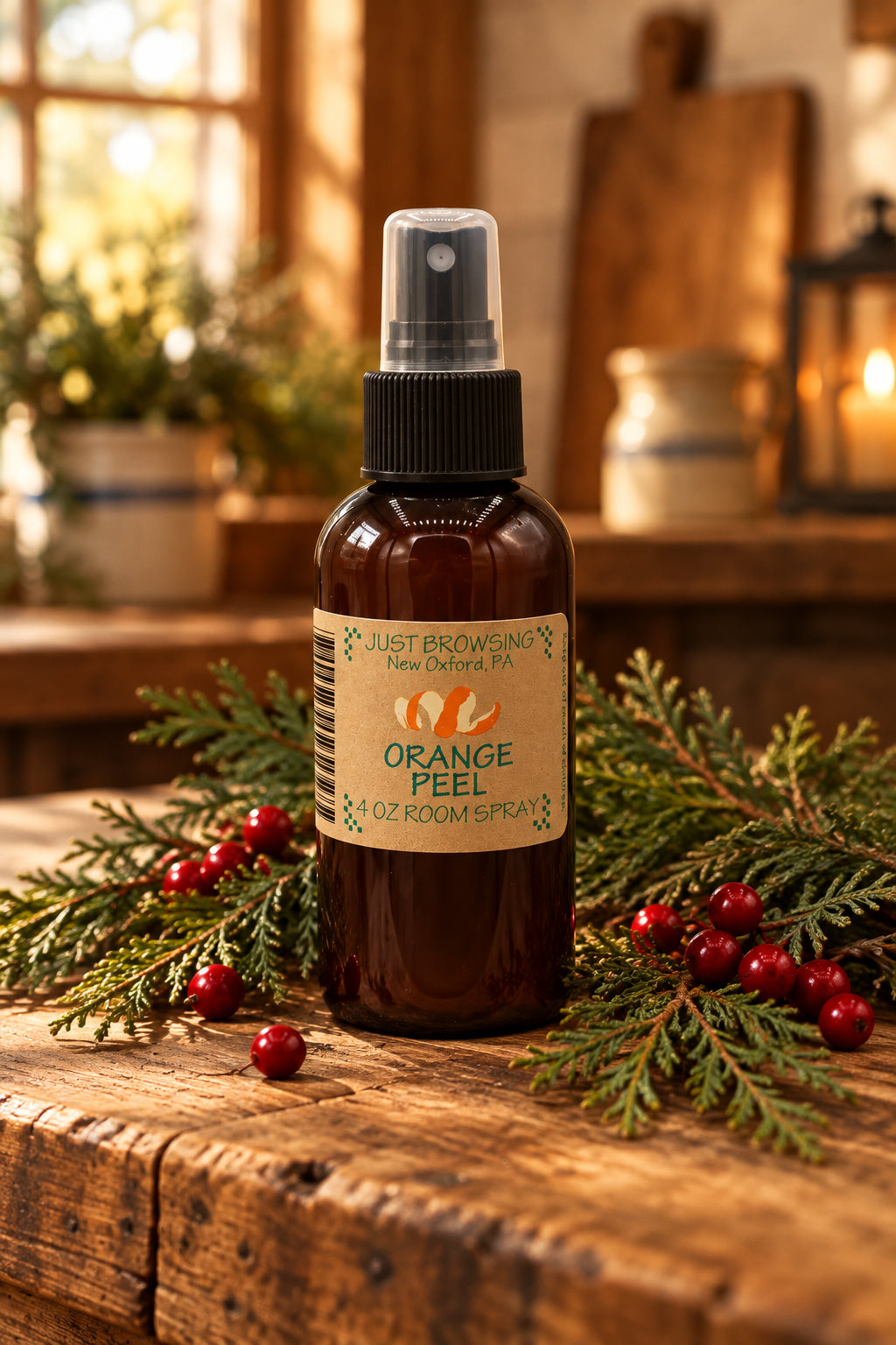 Bottle of orange peel room spray with a label on a surface with orange peels and cinnamon sticks.