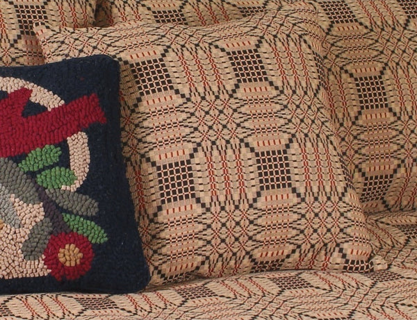 Textile with geometric pattern and a colorful embroidered pillow.