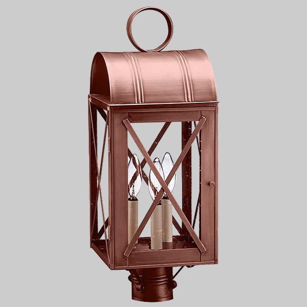 Copper outdoor lantern with two visible light bulbs on a gray background