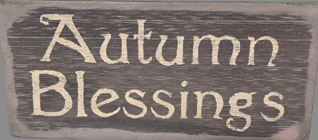 A wooden sign with the text 'Autumn Blessings' carved on it, displaying a rustic and seasonal design.