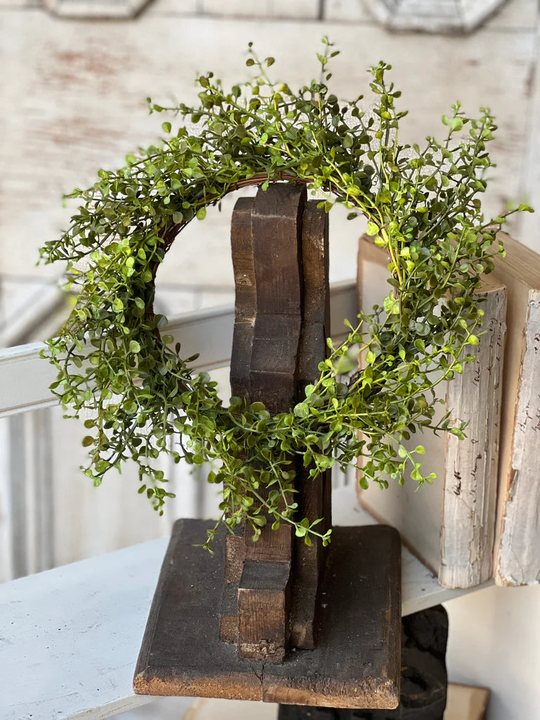 Decorative bookend with green foliage on a rustic wooden surface
