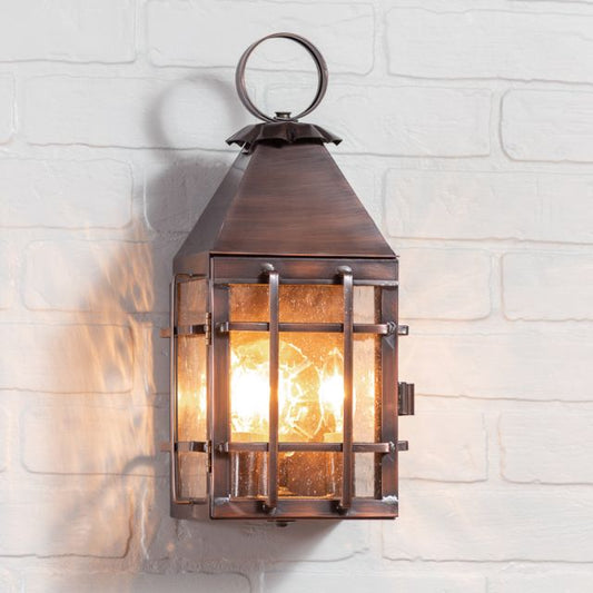 Decorative wall-mounted lantern with warm glow on a white brick wall background
