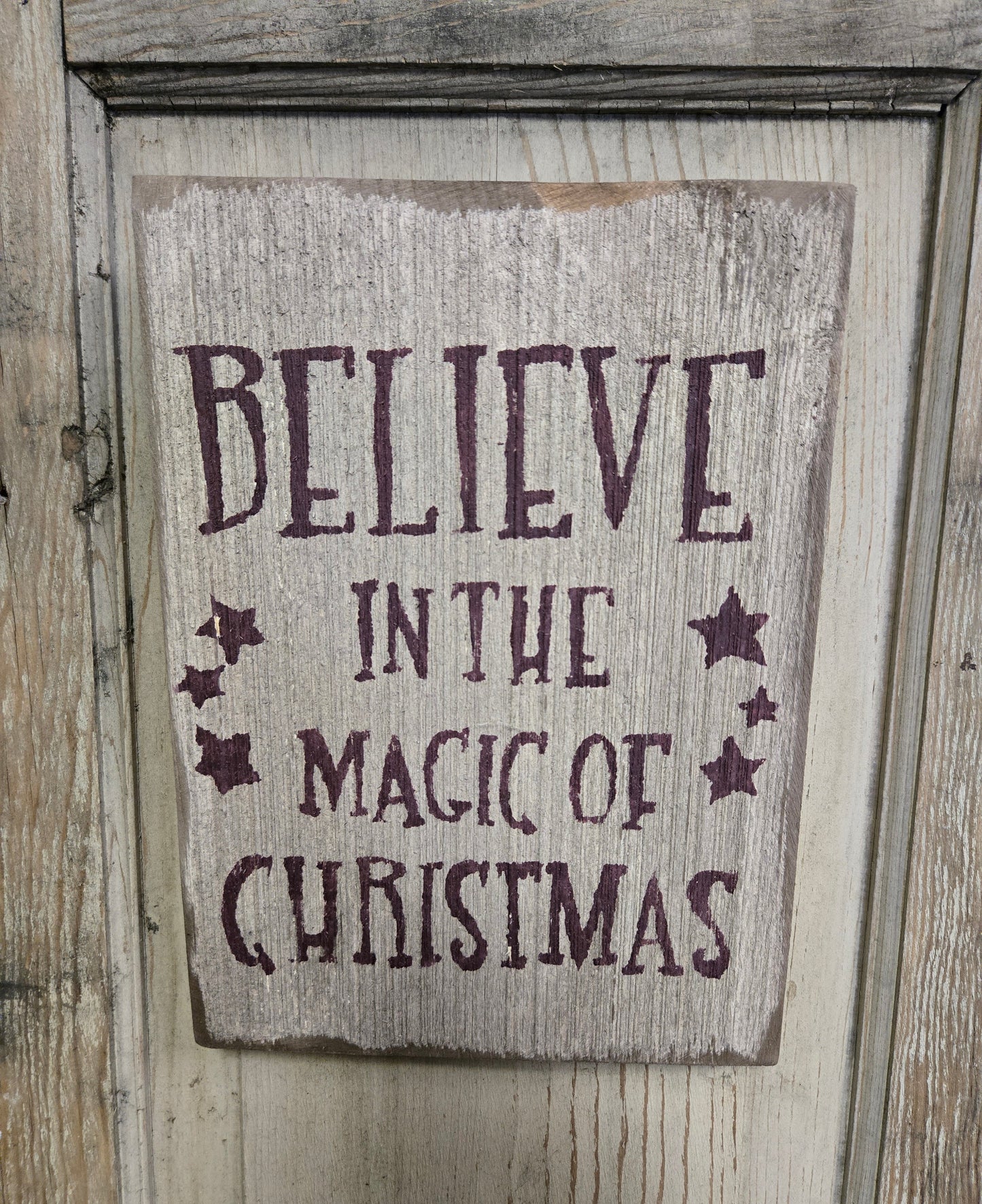 Weathered sign about Christmas on a wood door