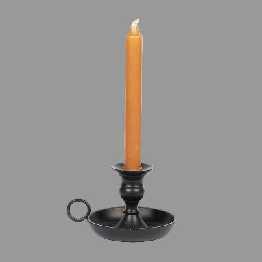 A black metal candle holder with a cylindrical base and a simple design, featuring a candle lit inside.