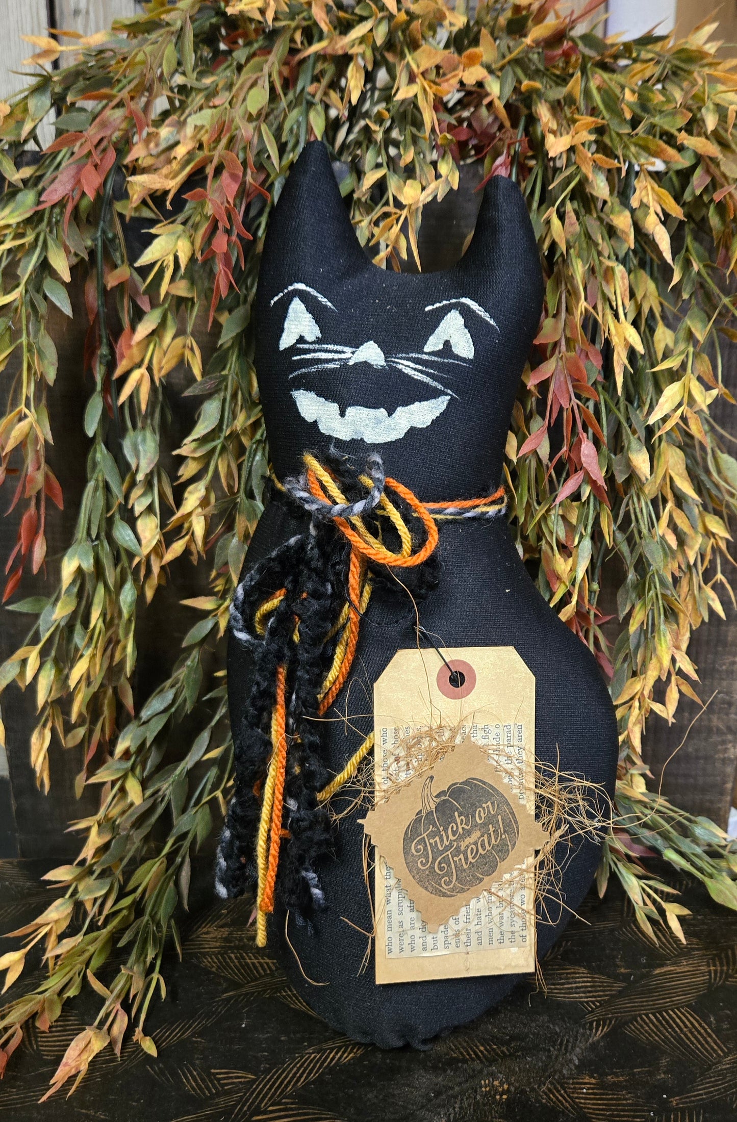 Black cat decoration with a tag on a wreath