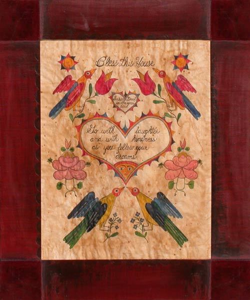 A colorful piece of folk art featuring birds, flowers, and a heart motif with a quote, mounted under glass.