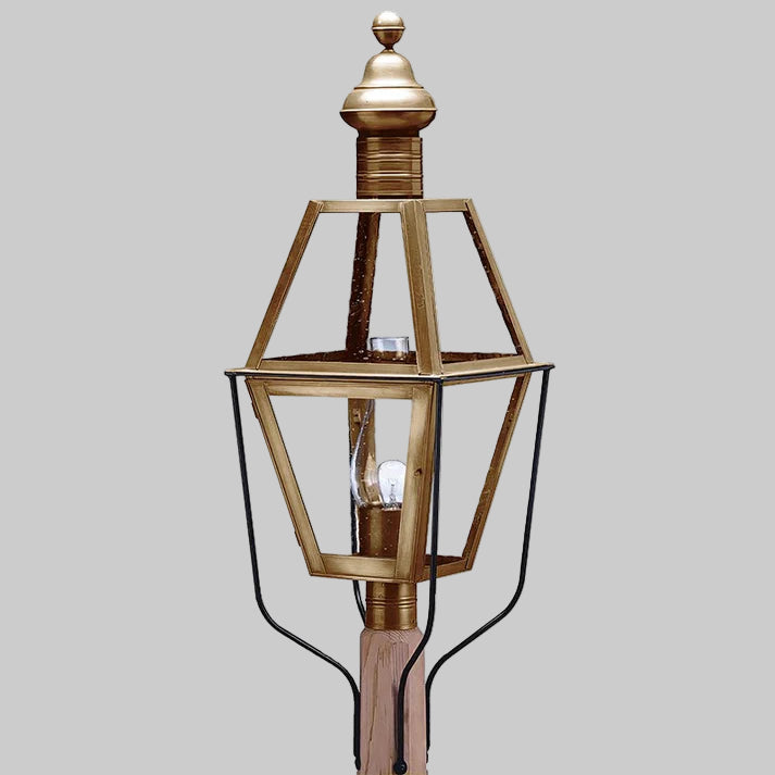 Decorative outdoor lamp with brass finish on a gray background
