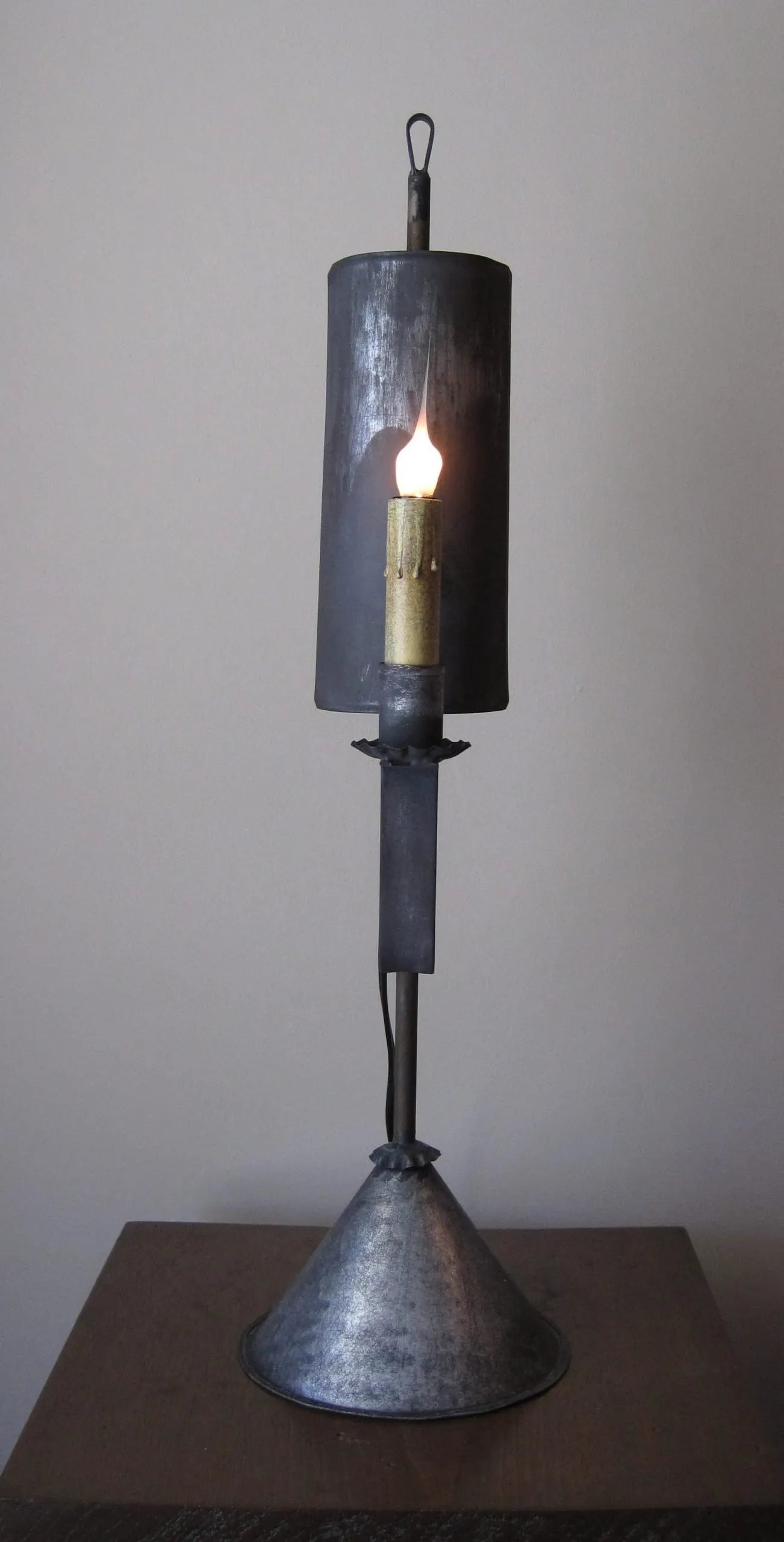 A Bristol Tin Table Light with a modern design, featuring a cylindrical tin body and a reverse curve stand.