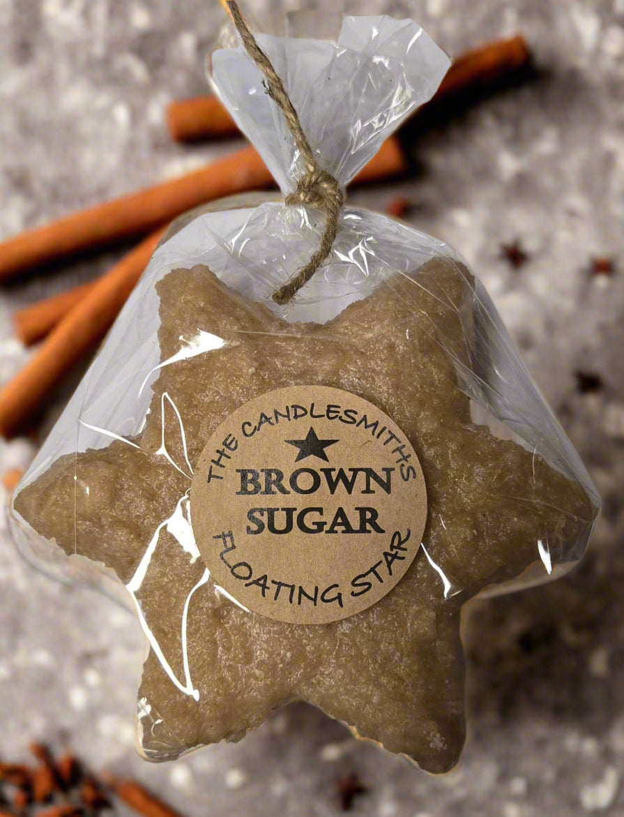 A brown star-shaped floating candle wrapped in plastic with a label that reads 'Brown Sugar Floating Star'.