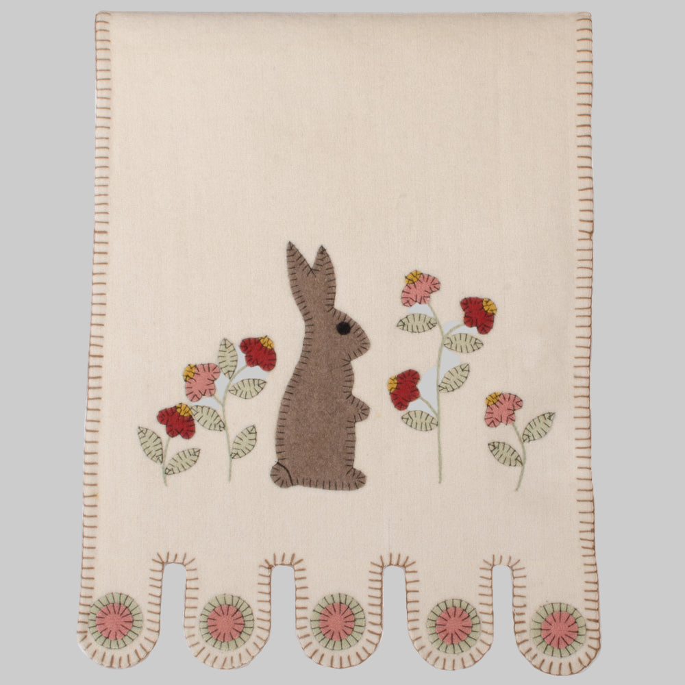 Cream colored table runner with bunny and flowers on white background