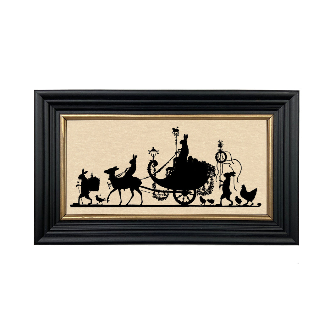A paper cut silhouette of a bunny parade, featuring a black frame with gold trim and a saw tooth picture hanger on the back.