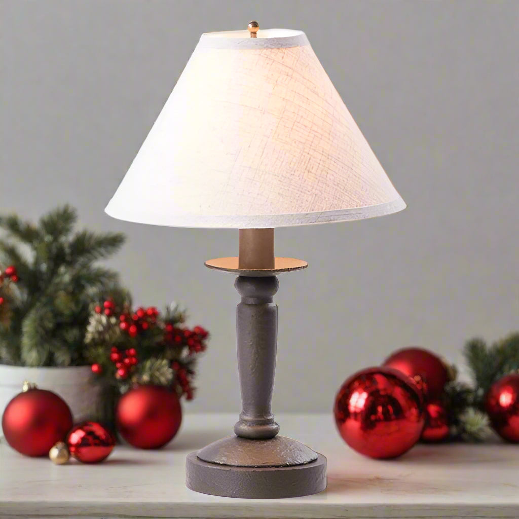 Table lamp with a textured base and white shade on a white background