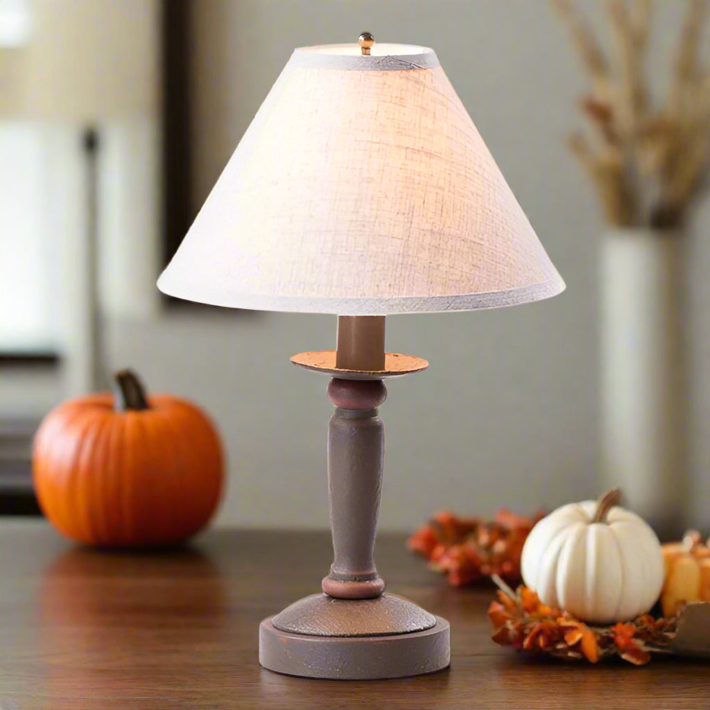 Table lamp with wooden base and white shade on a white background