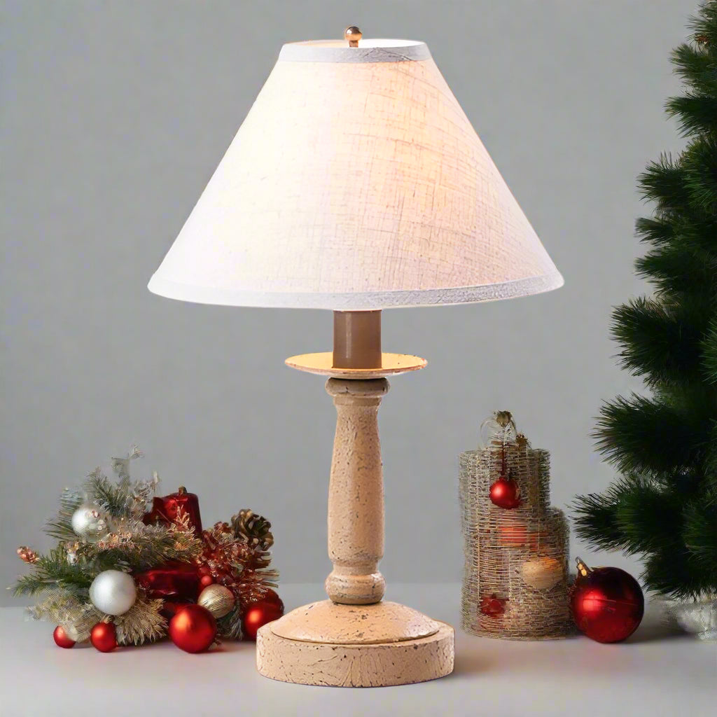 Table lamp with wooden base and white lampshade on a white background