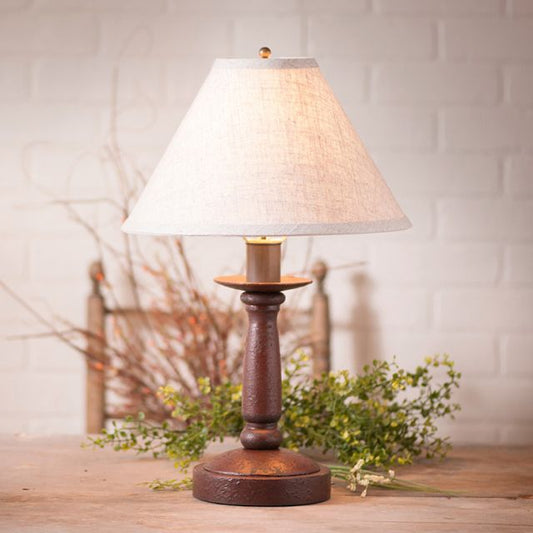 Table lamp with a wooden base and white shade on a wooden surface.