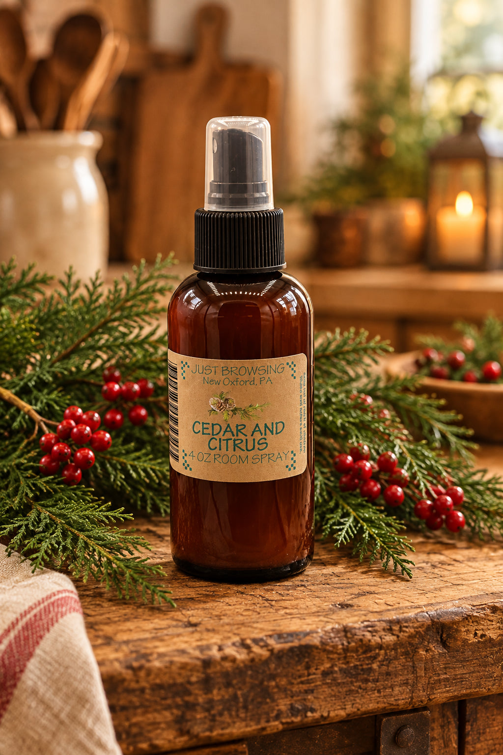 Bottle of Cedar and Citrus room spray with a label on a gray background with sprigs of cedar and oranges.