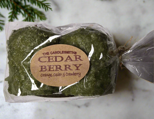 A pack of two green candles tied with a label that reads 'The Candlesmiths Cedar Berry'.
