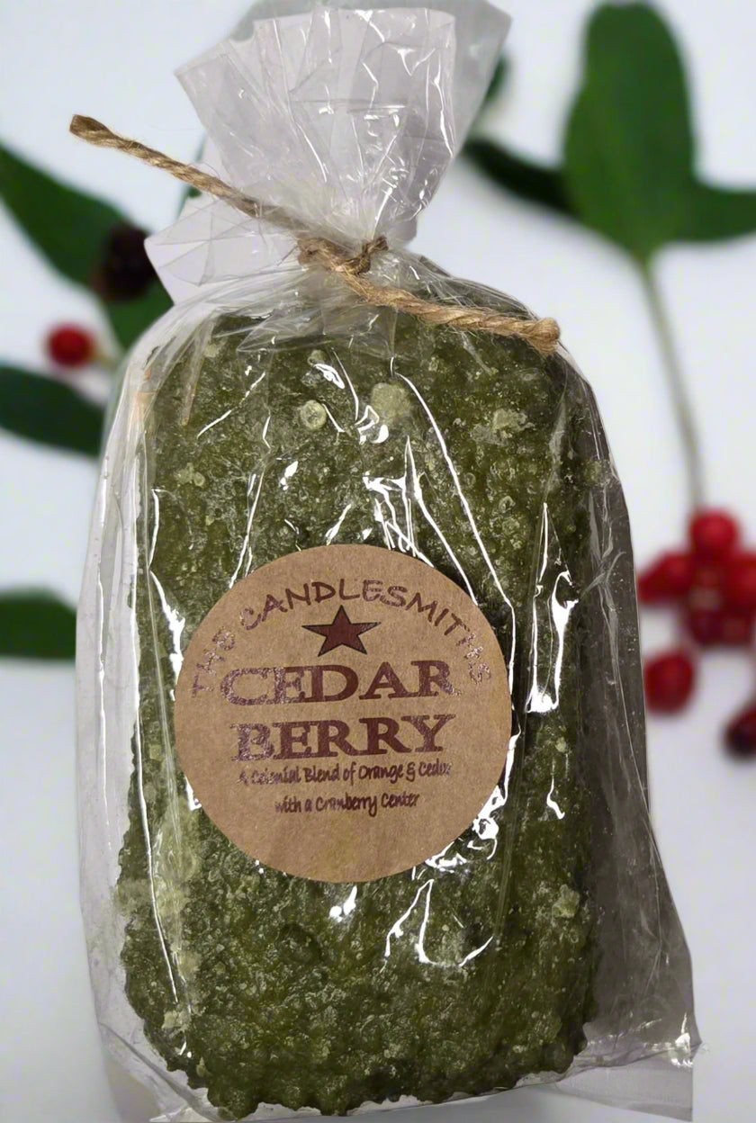 A Cedar Berry scented candle by Candlesmith, wrapped in wax paper and secured with a string, with a label that reads 'Cedar Berry' and the brand 'Candlesmith'.