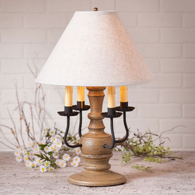 Table lamp with wooden base and white shade on a wooden surface with decorative elements.