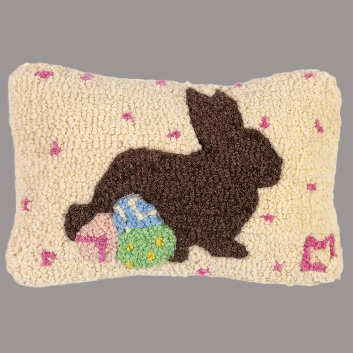 Decorative pillow with a bunny and Easter eggs design on a beige background
