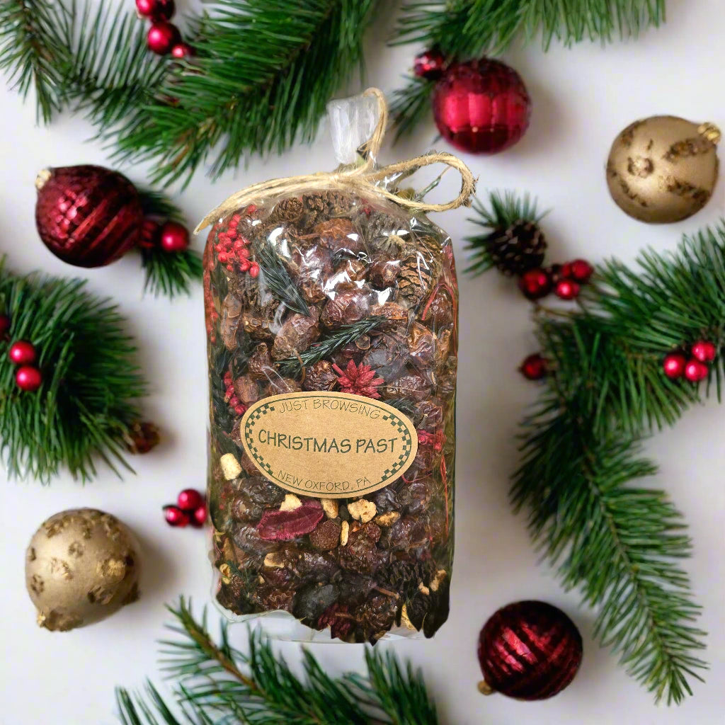 Packaged Christmas potpourri with a label on a bed of green leaves