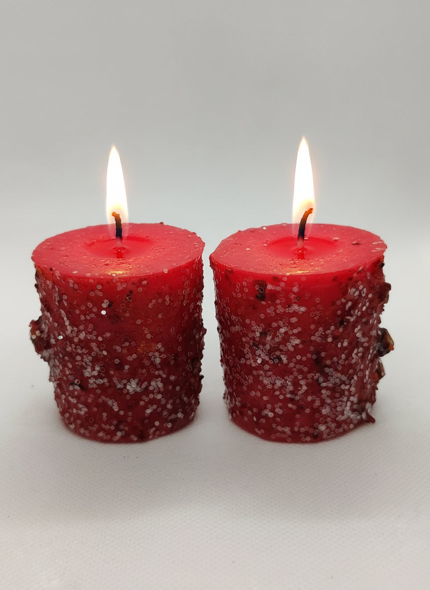 Two red textured candles on a white background