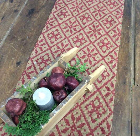 A short table runner with a Christmas rose pattern, featuring a decorative arrangement of Christmas roses on top.