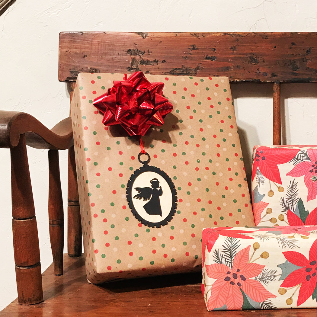 Gift box with polka dot pattern and red bow on a wooden surface