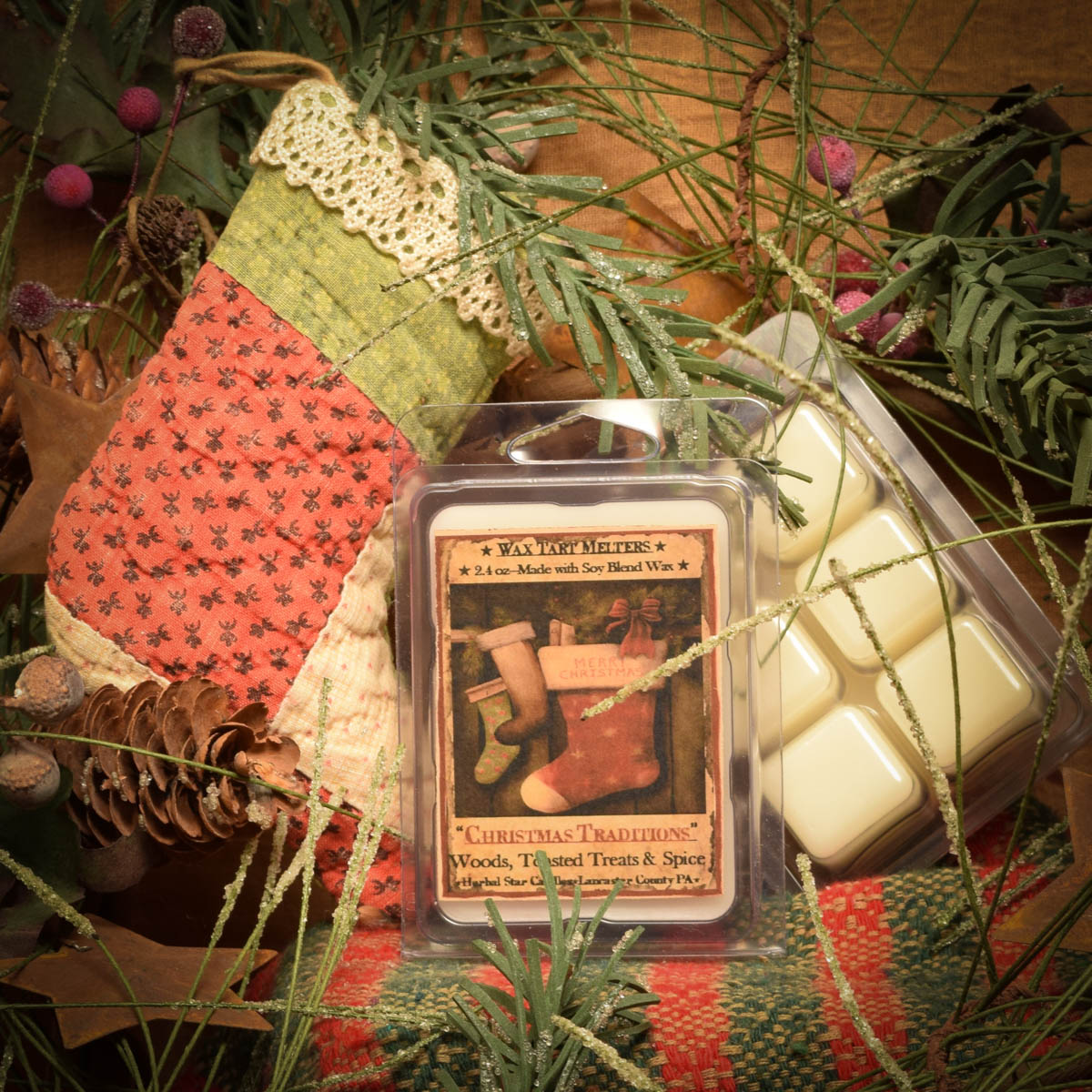 Mini pack of 6 Christmas-scented wax tarts in a clear plastic clamshell packet, displayed beside holiday-themed decorations.