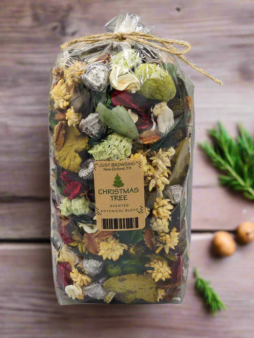 A bag of Christmas Tree Primitive Potpourri Blend, containing various botanicals and decorative accents, tied at the top with a string.