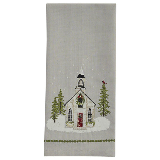 A Christmas-themed dishtowel featuring a church design with snow on the ground, trees, and a bird.