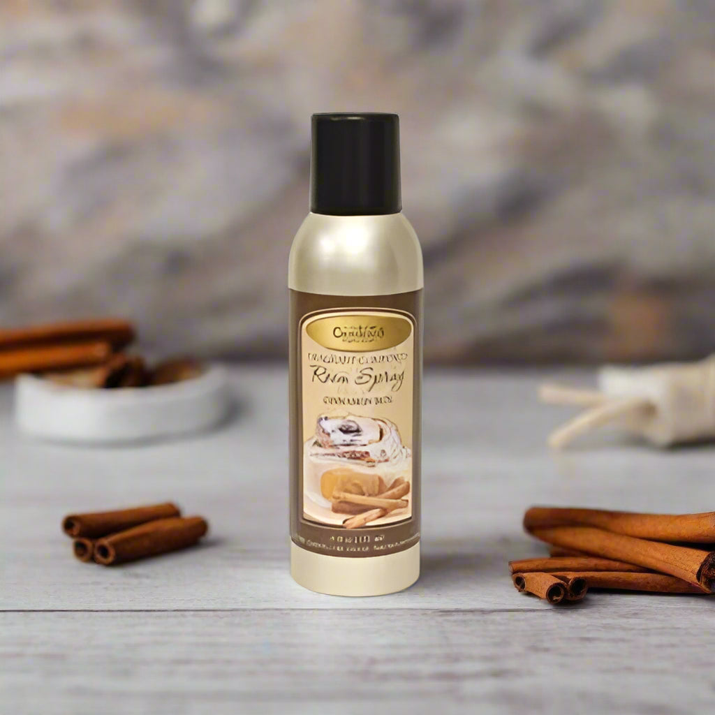 A bottle of Cinnamon Bun Room Spray by CWC Spray & Scent, featuring a label with an image of cinnamon buns and a sprinkle of spice.