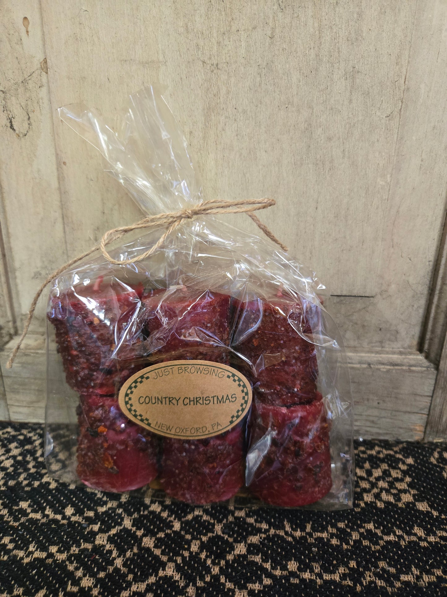 A pack of red tinted votive candles with a Christmas theme, sealed in clear packaging with a label that reads 'Country Christmas'.
