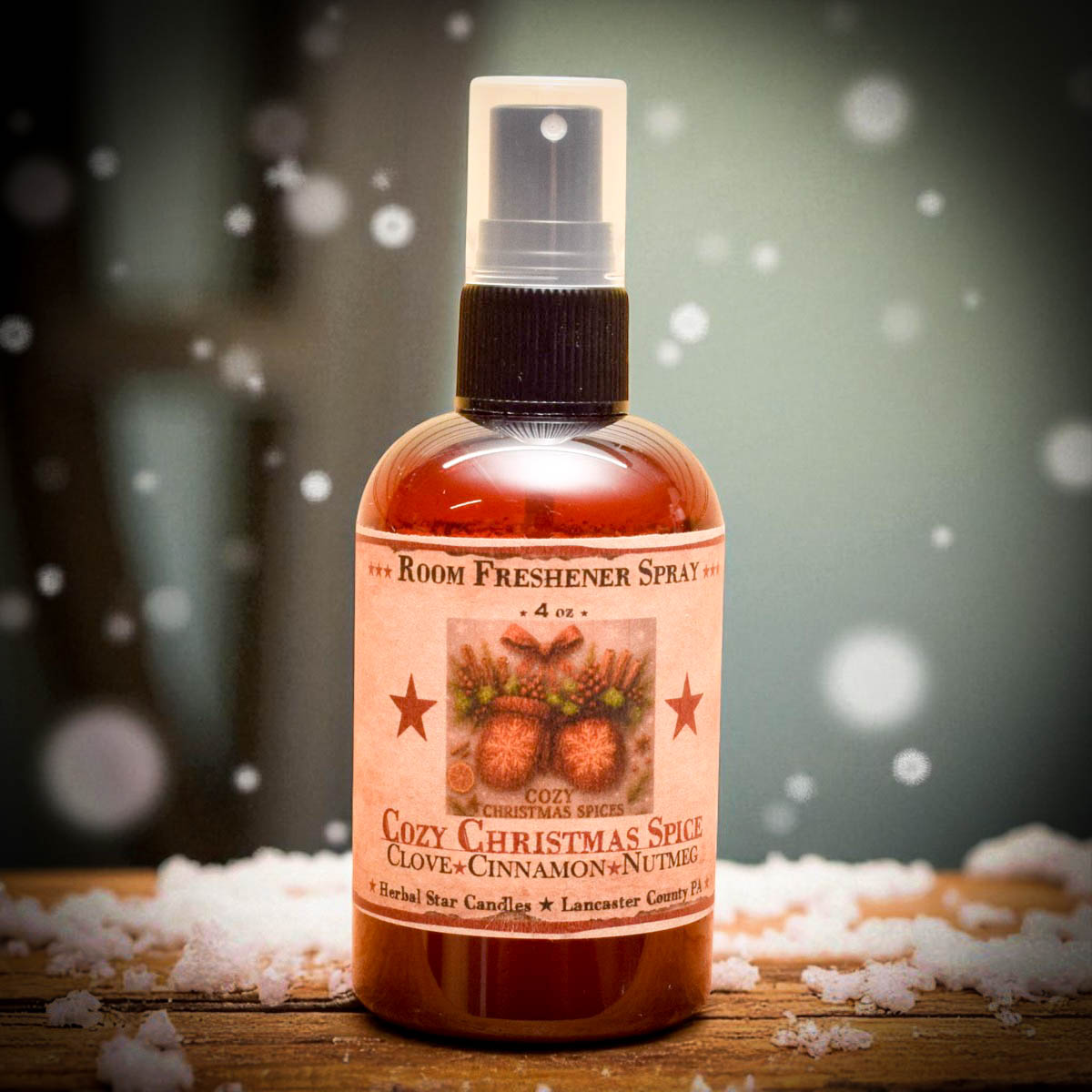Room freshener spray bottle labeled 'Cozy Christmas Spice' on a wooden surface with snowflakes in the background.