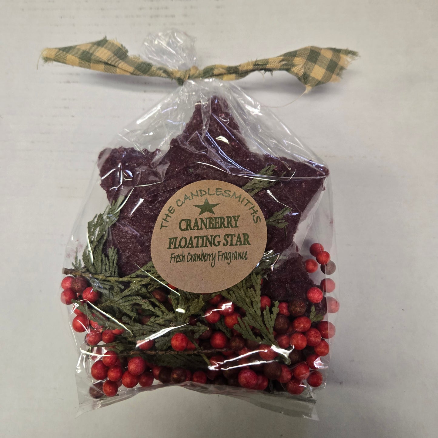 Packaged cranberry floating star with decorative label on a white background