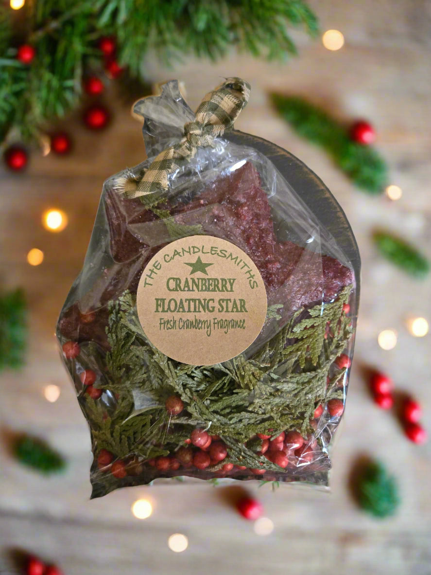 Cranberry floating star fragrance packet with Christmas decorations in the background
